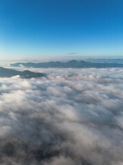 A high-angle landscape, dense fog, natural forest mountains covered in fog. A bright sky and beautiful landscape can be viewed from the sky with a drone.