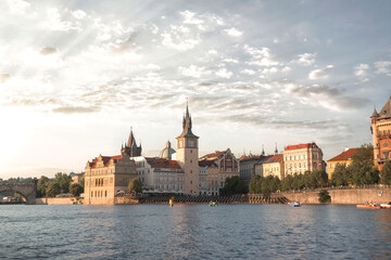 Fototapeta premium Sunny summer day: tourists delighting in a Vltava river boat excursion with stunning Prague landmarks. Czech Republic