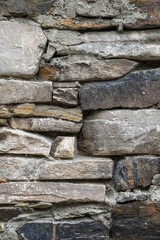 Texture of ancient wall made of natural stone blocks of different shapes, sizes and colors as a background
