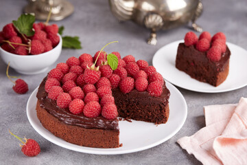 Chocolate sponge cake with chocolate cream and raspberries. Delicious homemade dessert.