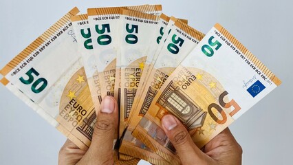 A closeup shot of hand holding 50 euro notes. Euro banknotes, European Union paper currency. Saving money concept. Finance, business, investment, inflation, purchasing power