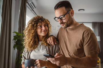 Portrait of adult couple husband and wife use mobile phone together