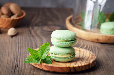 Green macarons with fresh mint on rustik wooden table.