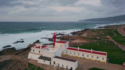 Drone beacon standing coastline cloudy evening. Red lighthouse at ocean shore