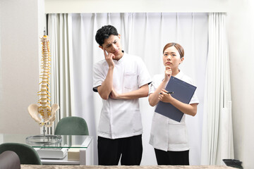 悩み中の白衣を着た医療従事者の男女