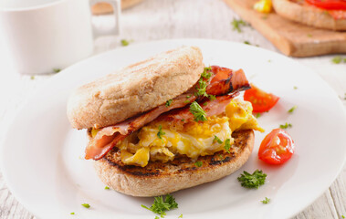 english muffin with bacon and fried eggs