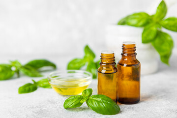 Basil essential oil on a textured wooden background. Basil essential oil and fresh leaves. Aromatherapy. Aroma oil. Medical herbs. Alternative medicine. Place for text. Copy space.