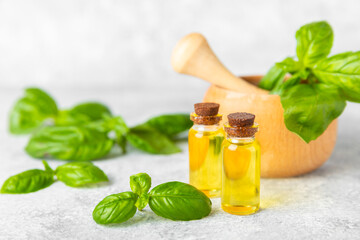 Basil essential oil on a textured wooden background. Basil essential oil and fresh leaves. Aromatherapy. Aroma oil. Medical herbs. Alternative medicine. Place for text. Copy space.