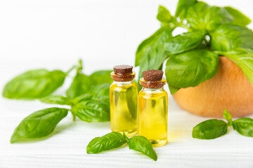 Basil essential oil on a textured wooden background. Basil essential oil and fresh leaves. Aromatherapy. Aroma oil. Medical herbs. Alternative medicine. Place for text. Copy space.