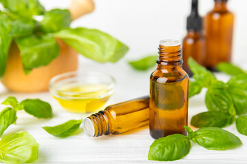 Basil essential oil on a textured wooden background. Basil essential oil and fresh leaves. Aromatherapy. Aroma oil. Medical herbs. Alternative medicine. Place for text. Copy space.