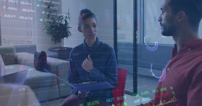 Image of graphs and trading boards over diverse coworkers discussing in office