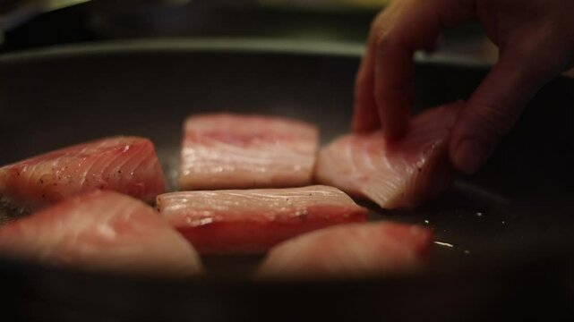 Chef Placing Fish Steaks On A Hot And Sizzling Fry Pan.