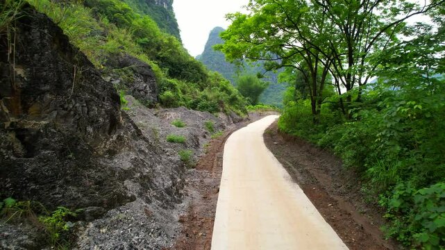 Newly established road path cuts across landscape in Yangshuo, China. Aerial dolly