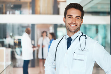 Doctor, face and confidence in hospital for healthcare, wellness or medical experience with stethoscope. Man, portrait and smile as surgeon in health facility with pride for cardiology or medicine