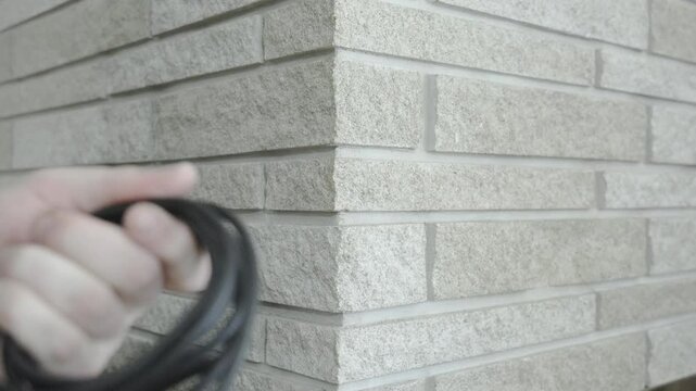 Foreground out of focus as a man wraps cords.