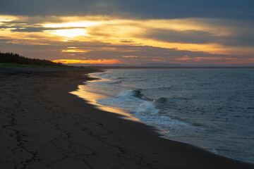 Obraz premium Dramatic sunrise view of waves crashing on the Longue-Pointe-de-Mingan beach in the summer, Quebec, Canada