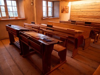 Vintage classroom with wooden desks and benches, evoking a nostalgic atmosphere.