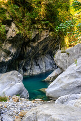 A vibrant green river flowing through a dramatic mountain canyon, showcasing the stunning natural beauty and dynamic landscape of the area on Shakadang Trail, Taroko National Park, Hualien, Taiwan