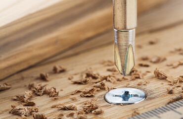 screwdriver screw in a wood oaks plank