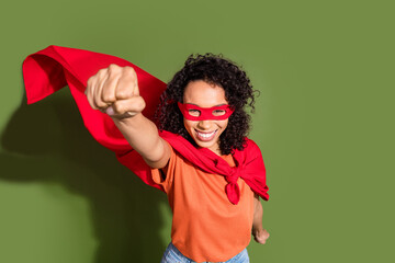 Photo portrait of pretty young girl flying strong superhero wear trendy orange outfit isolated on khaki color background © deagreez