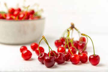 Cherries. Fresh ripe cherries with leaves on a textured wooden background. Fresh sweet organic cherry pile. Berries and fruits. Vegan. Healthy eating. Place for text. Copy space