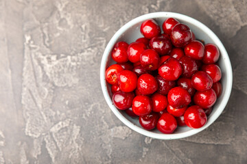 Cherries. Fresh ripe cherries with leaves on a textured wooden background. Fresh sweet organic cherry pile. Berries and fruits. Vegan. Healthy eating. Place for text. Copy space