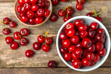 Cherries. Fresh ripe cherries with leaves on a textured wooden background. Fresh sweet organic cherry pile. Berries and fruits. Vegan. Healthy eating. Place for text. Copy space