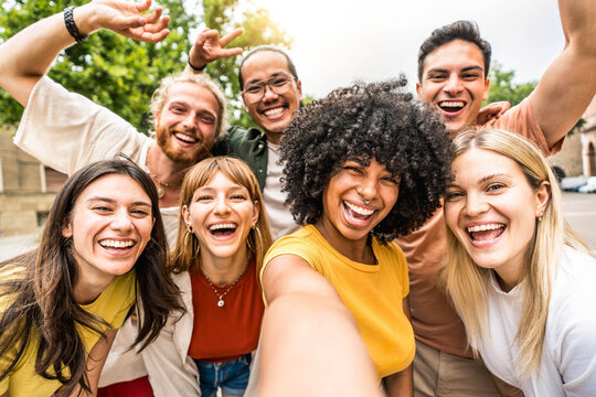 Multicultural friends smiling at camera together outside - Happy young people taking selfie with smart mobile phone device walking on city street - Youth community and technology concept