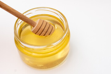 A jar of honey with a wooden dipper, essential for serving sweet treats