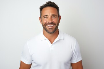 Portrait of a happy man in his 30s wearing a sporty polo shirt while standing against white background