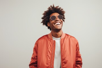 Obraz premium Portrait of a joyful afro-american man in his 20s wearing a trendy bomber jacket isolated on white background