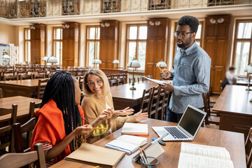 Group of young people discussing something in the library