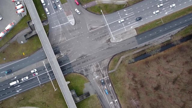 Topdown aerial view of cars crossing a intersection .