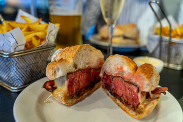 eating sirloin steak sandwich in a restaurant pub in Porto portugal with fries quality fast food