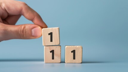 Hand arranging wooden blocks with number one on blue background