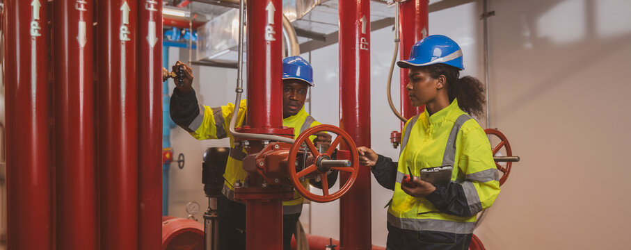 Engineer or technician work checking Fire suppression system and fire equipment. Engineer check red generator pump for water sprinkler piping and fire alarm control system