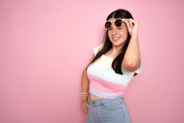 Photo of shiny impressed young woman wearing sunglasses isolated on pink background.