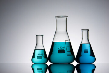 Three glass flask placed in a laboratory table with blue liquid