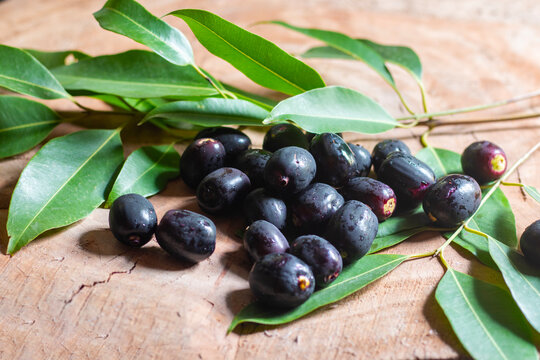 raw Jamun, black plum or java plum on an wooden background. 