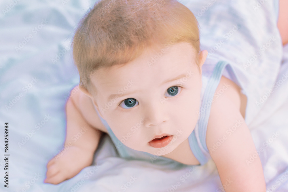 Wall mural cute baby boy lying on stomach and looking up