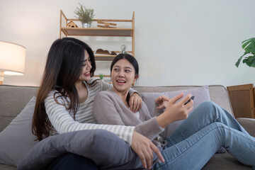 Obraz premium Lesbian Couple Enjoying Quality Time Playing Video Games Together in a Cozy Living Room Setting