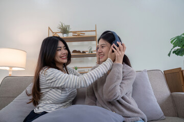 Lesbian Couple Relaxing at Home, Enjoying Quality Time Together on the Couch, Listening to Music and Sharing a Happy Moment