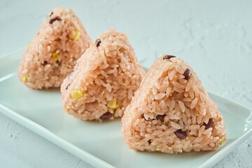 白いお皿に置かれた日本食の赤飯のおにぎり