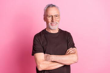 Portrait of toothy beaming nice man with beard dressed brown t-shirt in glasses holding arms...