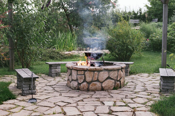 Food is cooked in a cauldron over a fire in the center of the patio. Beautiful stone paving and an abundance of plants make the landscape uniquely beautiful. A series of lifestyle photographs.