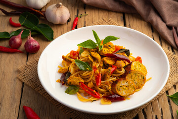 Stir fried Spaghetti with Northern Thai spicy sausage.pasta with chilli garlic and basil leaves in white plate.Thai fusion food.