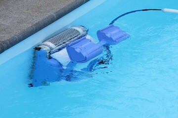 Swimming pool cleaning . Swimming pool robot cleans the side of the pool in summer. 