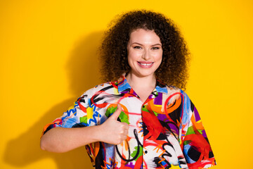 Photo portrait of lovely young lady thumb up dressed stylish colorful print garment isolated on yellow color background