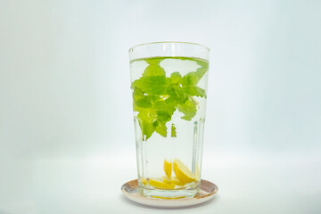 A glass of Mint Lemonade Water in it  with Green leaves Isolated Cold Lemon Gin Tonic 