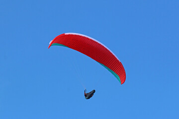 Paraglider flying in a blue sky
